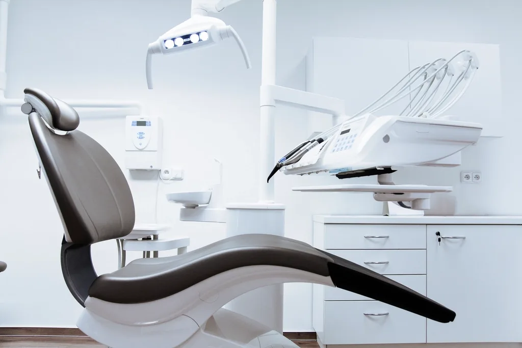 Consultorio de Clínica Norte: sillón dental moderno en una sala blanca y luminosa