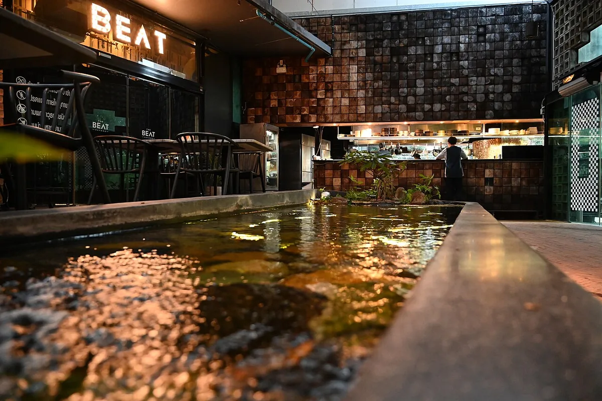 Interior de restaurante en penumbra con cocina abierta